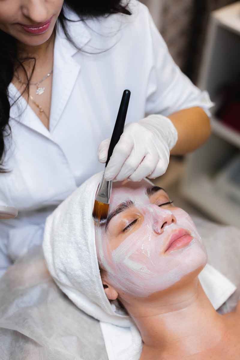 Beauty therapist giving a facial